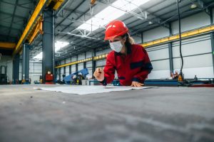 female-worker-in-safety-helmet-and-uniform-working-with-blueprints-.jpg